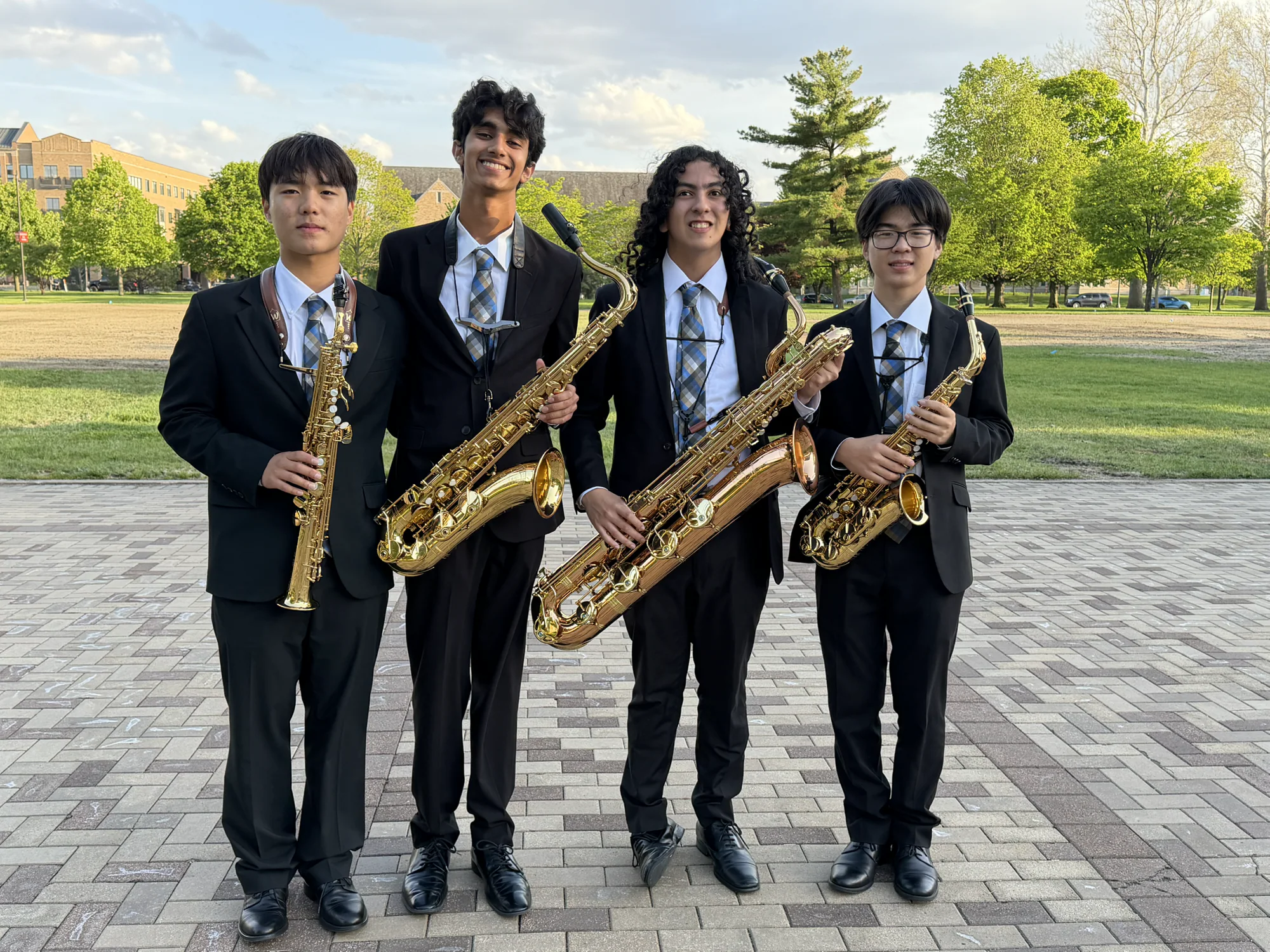 The Caelum Quartet standing outdoors with their saxophones